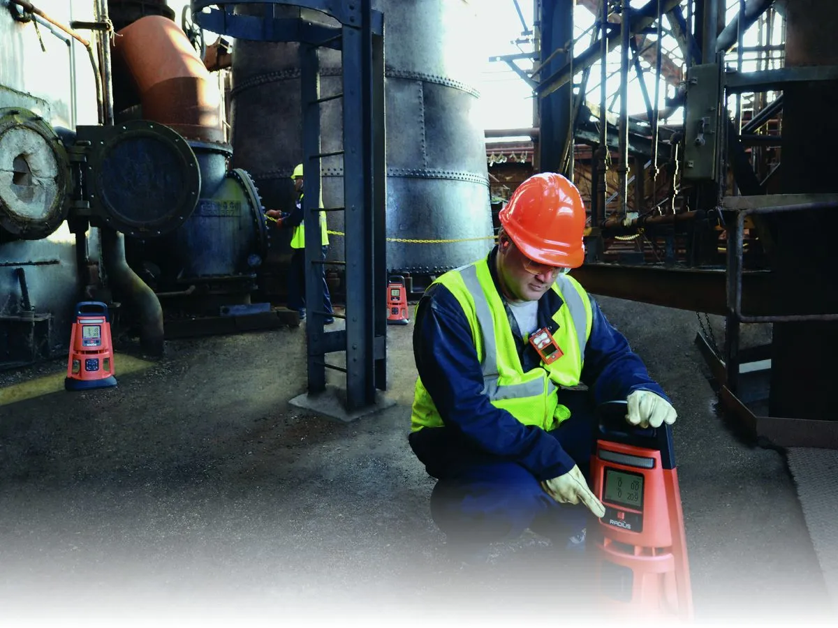 Industrial Scientific Radius BZ1 area gas monitor deployed inside an active treatment plant by a technician in PPE
